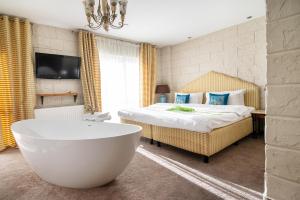 a bedroom with a tub and a bed and a tv at Hotel Azzun Orient SPA&Wellness in Kromerowo