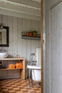 a bathroom with a tub and a sink at Vakantiehoeve Amadee in Zonnebeke