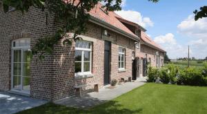 a brick house with a bench in front of it at Vakantiehoeve Amadee in Zonnebeke