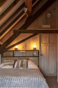 a bedroom with a large bed with a wooden ceiling at Vakantiehoeve Amadee in Zonnebeke +44 photos