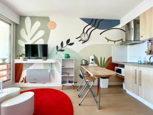 une cuisine avec une table et un tapis rouge dans l'établissement STUDIO VUE MER Quartier des Quilles, à Sète 2 autres photos