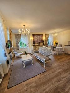 a living room with a couch and chairs and a table at La Maison Chaleureuse in Ribérac