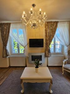 a living room with a chandelier and a coffee table at La Maison Chaleureuse in Ribérac