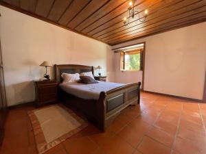 a bedroom with a bed and a wooden ceiling at Casa d'Avó Lina - Gerês in Terras de Bouro +36 photos