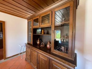 a wooden cabinet with vases in it in a room at Casa d'Avó Lina - Gerês in Terras de Bouro