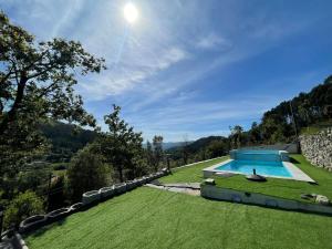 an image of a swimming pool in a grass field at Casa d'Avó Lina - Gerês in Terras de Bouro