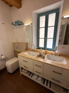 a bathroom with two sinks and a toilet and a mirror at Entre Ciel et Mer in Bonifacio