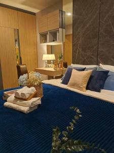 a bedroom with a large bed with blue sheets at DiamondHouse in Hat Yai