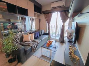 a living room with a couch and a large window at DiamondHouse in Hat Yai