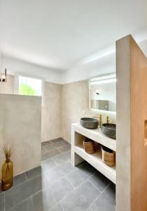 La salle de bains est pourvue de 2 lavabos et d'un miroir. dans l'établissement Maison de 2 chambres avec piscine partagee jardin clos et wifi a Ghisonaccia, à Ghisonaccia