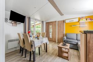 a dining room and living room with a table and chairs at Mobile home Gastes in Gastes