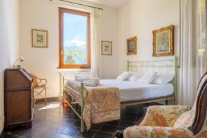 una camera con un letto e una sedia e una finestra di Villa Gilda - Griante a Griante Cadenabbia