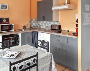 una pequeña cocina con mesa y fregadero en Maison d'une chambre avec jardin clos et wifi a L'Isle sur la Sorgue, en LʼIsle-sur-la-Sorgue