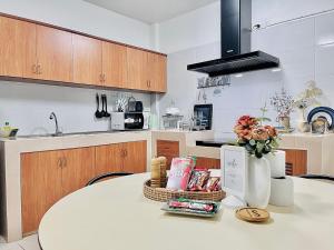 a kitchen with a table with a vase of flowers at Genesis Urban Phuket in Ban Lo Long