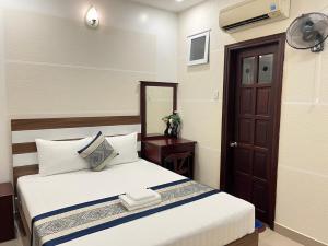 una camera d'albergo con letto e specchio di DINH DINH 2 AIRPORT HOTEL ad Ho Chi Minh