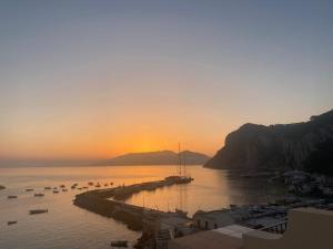 a sunset over a harbor with boats in the water at Mama' in Capri