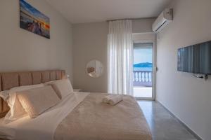 a bedroom with a bed with a view of the ocean at Esel Apartments in Sarandë +125 photos