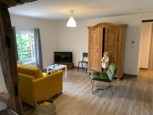 a living room with a yellow couch and a tv at Appartement Les Vendanges Parking privé Gites1596 in Beblenheim
