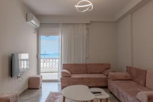 a living room with a couch and a tv at Esel Apartments in Sarandë
