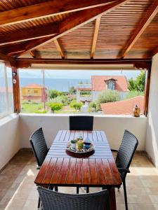 a wooden table and chairs on a balcony at Elia - Seaside Home in Nea Potidaea