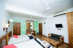 a room with two beds and a tv at Hotel Sea Line in Galle