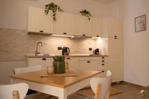 een keuken met een houten tafel en witte kasten bij Camilla's home in Turijn