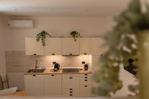 een keuken met witte kasten en een spoelbak bij Camilla's home in Turijn +13 foto's