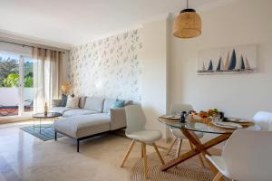 a living room with a couch and a table at Modern Sea & Golf View 2-Bedroom Apartment with Pool and Terrace in Calanova in Mijas