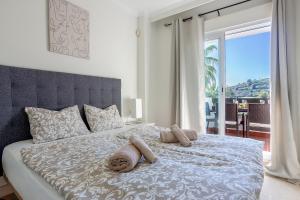 a bedroom with a bed with a view of a balcony at Modern Sea & Golf View 2-Bedroom Apartment with Pool and Terrace in Calanova in Mijas