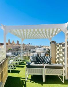 eine weiße Pergola auf dem Dach eines Gebäudes in der Unterkunft Casa Birmula Boutique Hotel in Cospicua