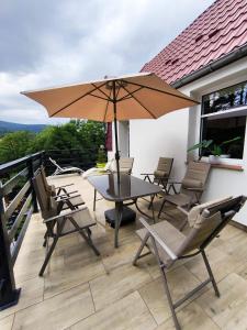 シフィエラドゥフ・ズドルイにあるIZERSKI TARAS- Górski Apartament 120m2のテーブルと椅子と傘のあるパティオ
