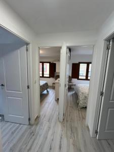 a room with two beds and a hallway with two doors at Apartamentos BuenaVista in Colunga
