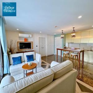 un salon avec un canapé et une table et une cuisine dans l'établissement Espana Hotel Jomtien Beach Pattaya, à Jomtien Beach