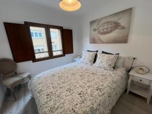 a bedroom with a bed and a chair and two windows at Apartamentos BuenaVista in Colunga +44 photos
