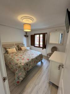 a bedroom with a bed and a window and a table at Apartamentos BuenaVista in Colunga