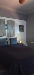 ein Schlafzimmer mit einem großen Bett und blauen Kissen in der Unterkunft Appartement Le Rescator à Tamaris vue mer exceptionnelle climatisé résidence avec piscine et parking in La Seyne-sur-Mer