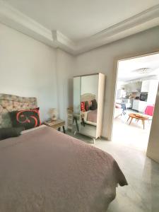 - une chambre avec un lit et un grand miroir dans l'établissement One bedroom apartement with sea view shared pool and balcony at Hergla, à Harqalah