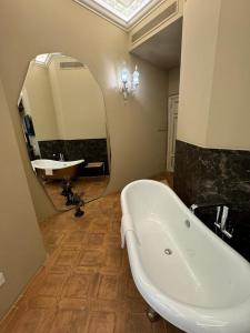 ein Badezimmer mit einer Badewanne, einem Waschbecken und einem Spiegel in der Unterkunft Delle Nazioni Milan Hotel in Mailand