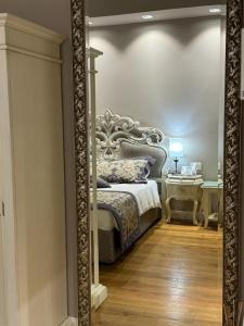 espejo que refleja un dormitorio con cama y escritorio en Delle Nazioni Milan Hotel en Milán