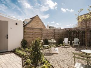 a backyard with a fence and a table and chairs at Strandhotel Domburg - Next Door in Domburg