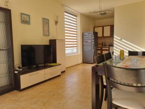 a living room with a television and a dining room table at Apartment Kalin complex Aurelia-RAVDA in Nesebar