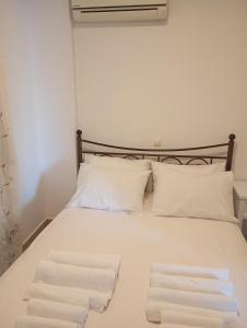 uma cama branca com duas toalhas em cima em IFESTIA HOUSE em Agia Paraskevi