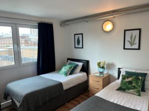 a bedroom with two beds and a window at Access Apartments City in London