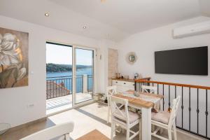a dining room with a table and chairs and a television at Bobel Deluxe Tiny House in Povlja