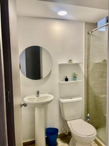 a bathroom with a toilet and a sink and a mirror at Ciudad Mallorquin in Puerto Colombia +10 photos