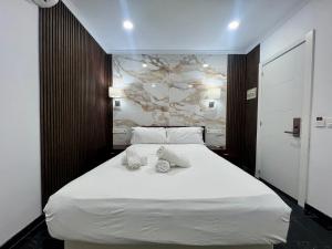 a bedroom with a large white bed with towels on it at Boutique Princesa in Marbella
