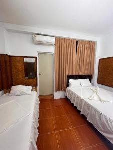 um quarto com duas camas e uma janela em Hospedaje el Emperador em Pucallpa