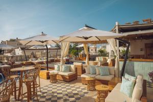 a patio with tables and chairs and umbrellas at Sophia Hotel in Cartagena de Indias