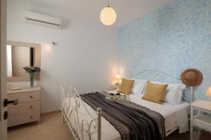 a bedroom with a bed with a blue wall at 9 Muses Naxos Beach hotel in Kastraki