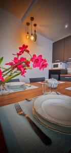 a table with a plate and a vase of pink flowers at Sweet Home in Serravalle Sesia